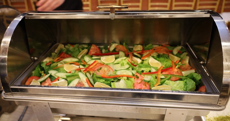 A large metal tray filled with a variety of fresh salad ingredients