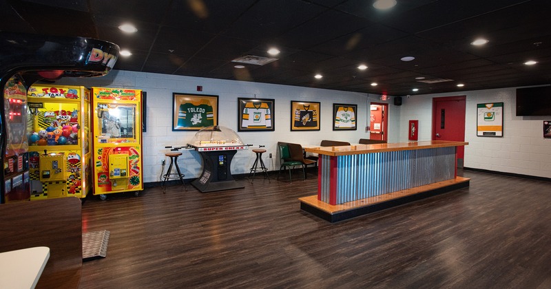 Interior of game room area with claw arcade machines and a dome hockey table
