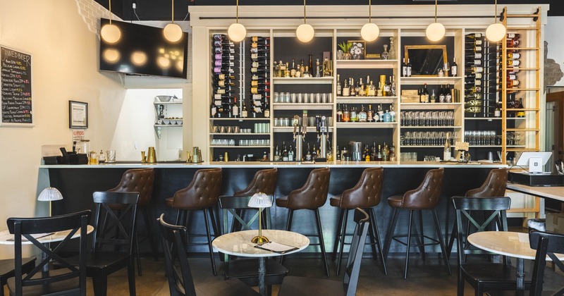 View of a bar area, shelves with drinks behind the bar