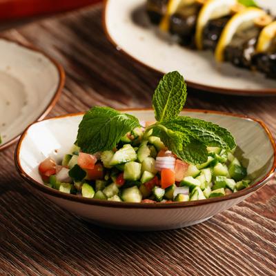 Sa;lad with tomato, onion, cucumbers, and parsley.