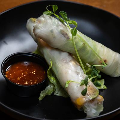 Fresh spring rolls served with sweet chili sauce and microgreens.