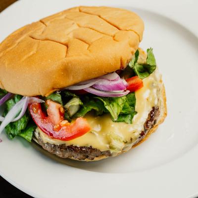 Cheeseburger with melted cheese and fresh toppings.