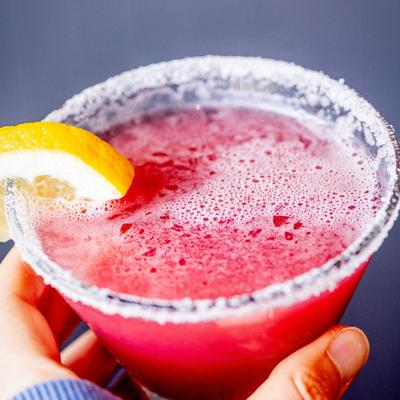 A hand holding the strawberry lemon drop drink.