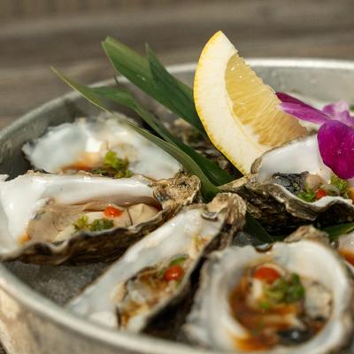 Raw oysters, with ponzu, scallions, and sriracha.