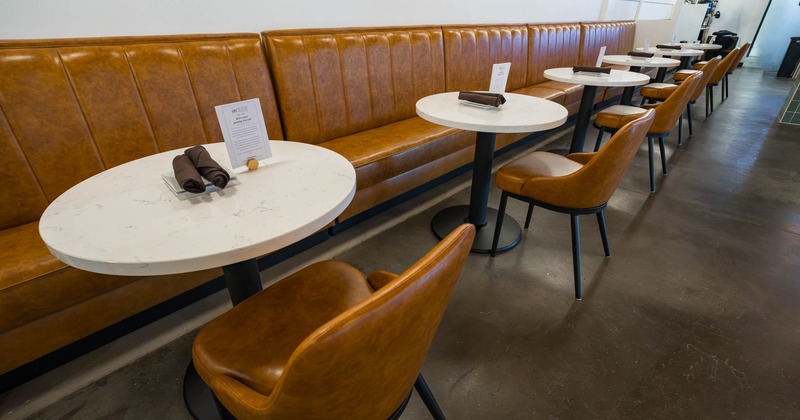Interior, Caramel leather banquette seating with round white cafe tables