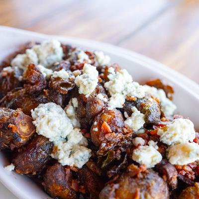 Balsamic Brussel Sprouts topped with crumbled cheese, close up.