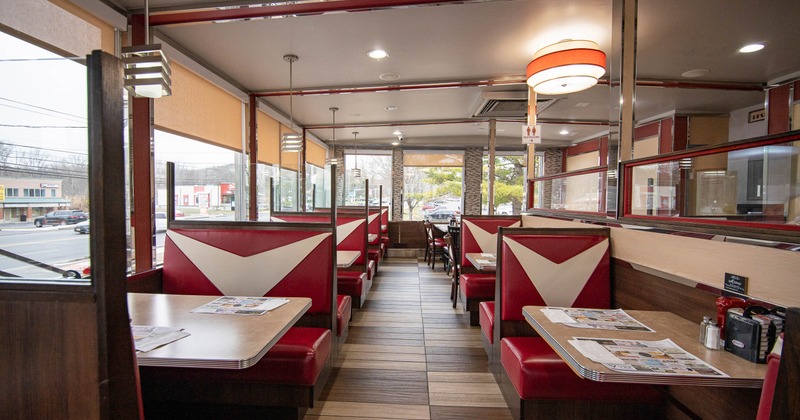 Retro-style diner interior with red and white booths lining both sides