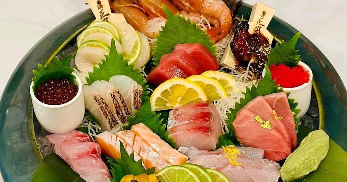 Assorted sashimi platter with tuna, salmon, shrimp, lemon, and wasabi