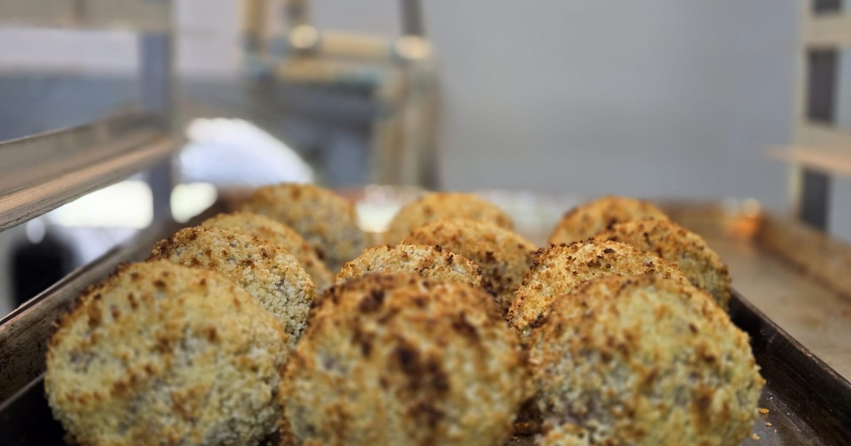 Tray of croquettes coated in breadcrumbs, close-up