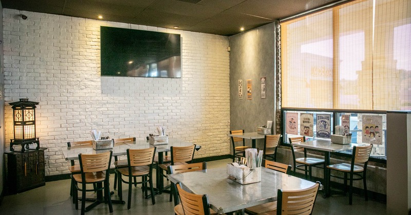 Interior, dining area, tables for two, four and six, TV on a white brick wall