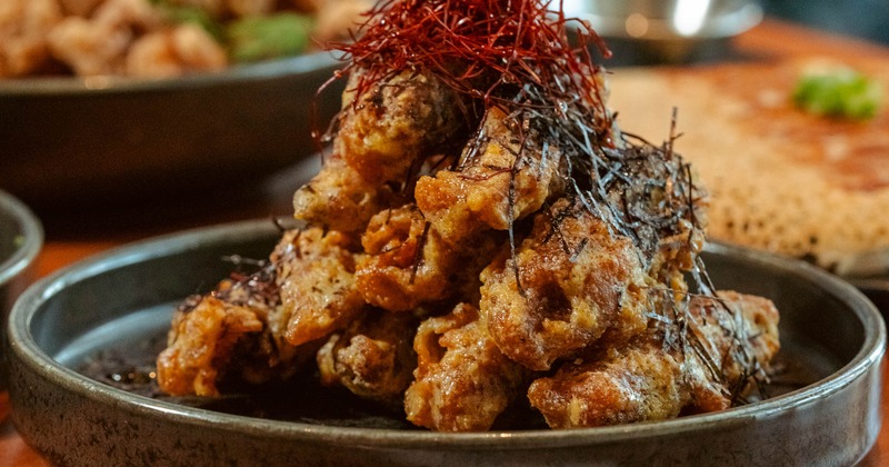 Plate of crispy fried chicken topped with shredded chili and seaweed