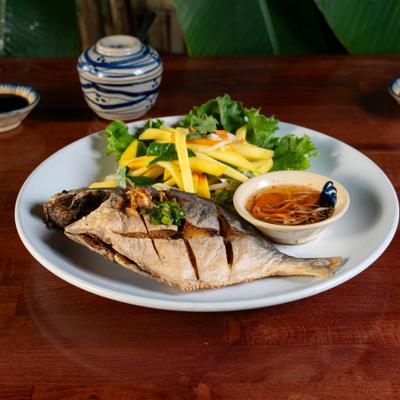 Crispy fried pompano fish served with green mango salad and fish sauce.