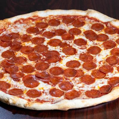 Whole Pepperoni pizza served on a wooden table.