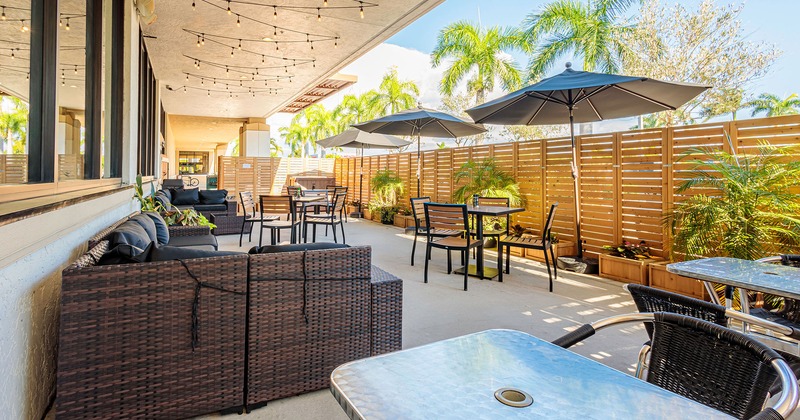 Partly covered patio with tables, chairs and outdoor lounge sofas