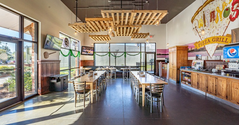 Interior, dining tables ready for guests, TVs on walls