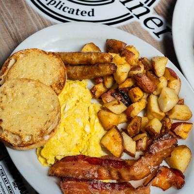 Scrambled eggs, bacon, potatoes, toast, and sausages.