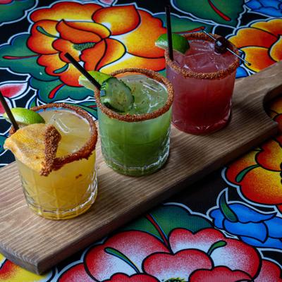 Margarita flight on a colorful floral tablecloth.