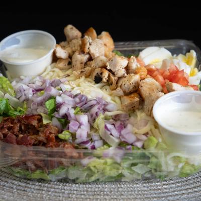 Grilled chicken salad with dipping sauces.