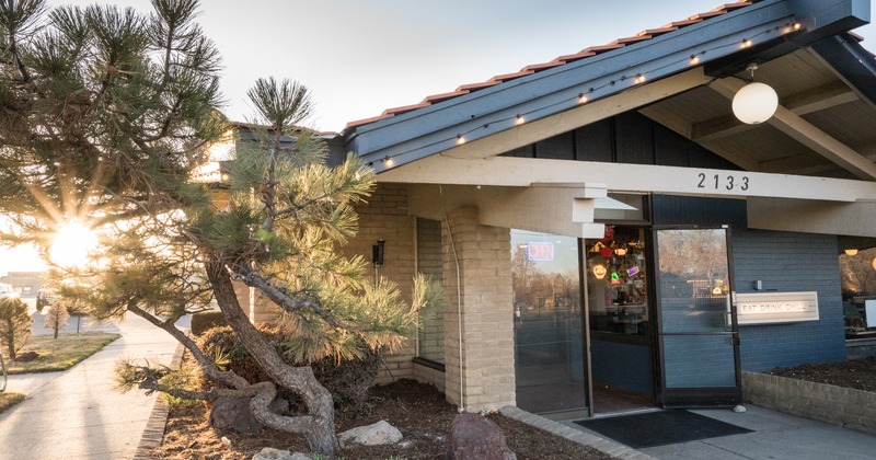 Front entrance of the restaurant with a pine in the foreground