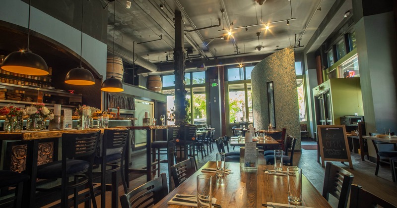 Interior, seating area, high and regular seating tables with chairs, bar on the left