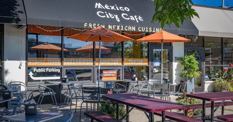Outdoor seating area with tables, benches and parasols