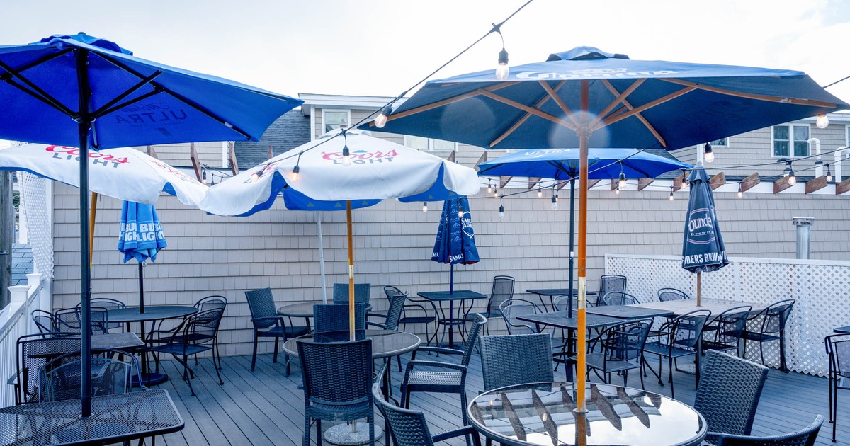 Outdoor patio with tables, wicker chairs and blue and white umbrellas