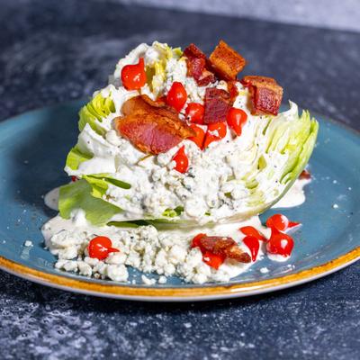 Wedge salad with bacon, blue cheese, and creamy dressing.