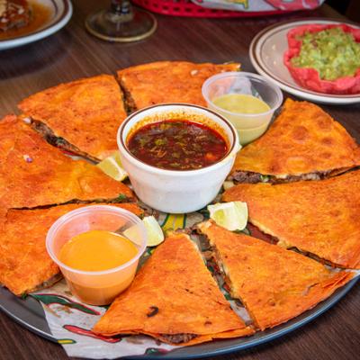 Birria Tacos served with salsas and consomme.