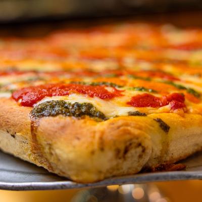 Pizza with vodka, tomato, and pesto sauces.