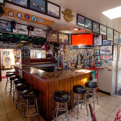 Bar area, bar corner with barstools and framed pictures.