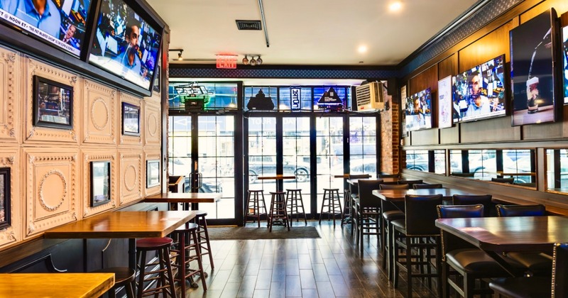 Interior with high top seating, TVs showing sports, and large windows