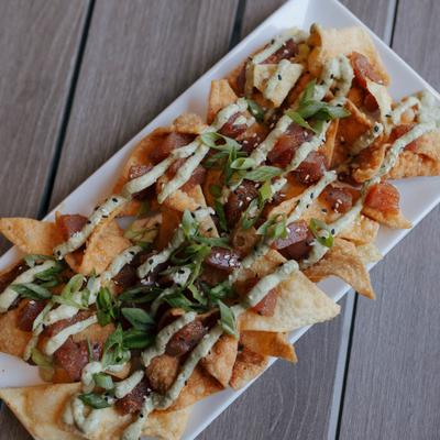 A plate of ahi tuna nachos sits on a patio table.