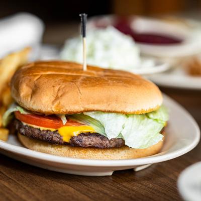 A close-up of a cheeseburger with lettuce and tomato.