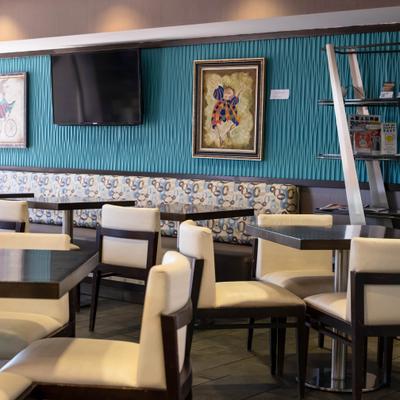 Interior with white and dark wood chairs, a blue textured accent wall, and framed artwork.