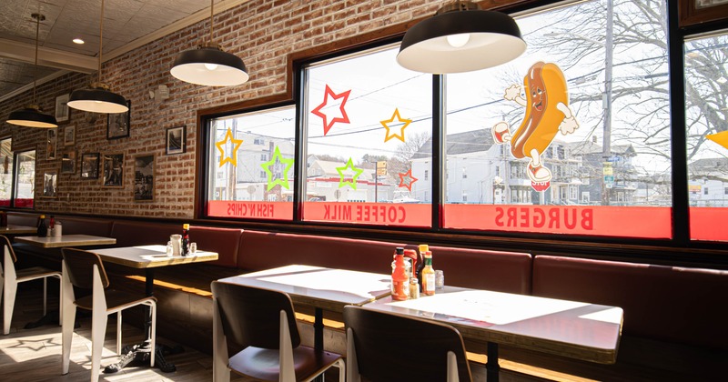 Interior - brick walls, tables with chairs, large windows and colorful window decals