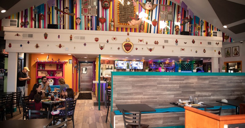 Interior, tables, chairs, benches, customers, various wall decorations, hanging figurines and symbols