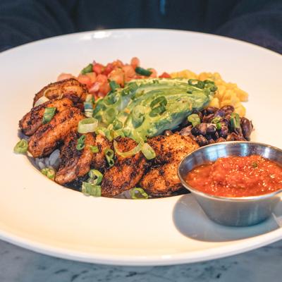 Spiced shrimp served with rice, beans, corn and avocado