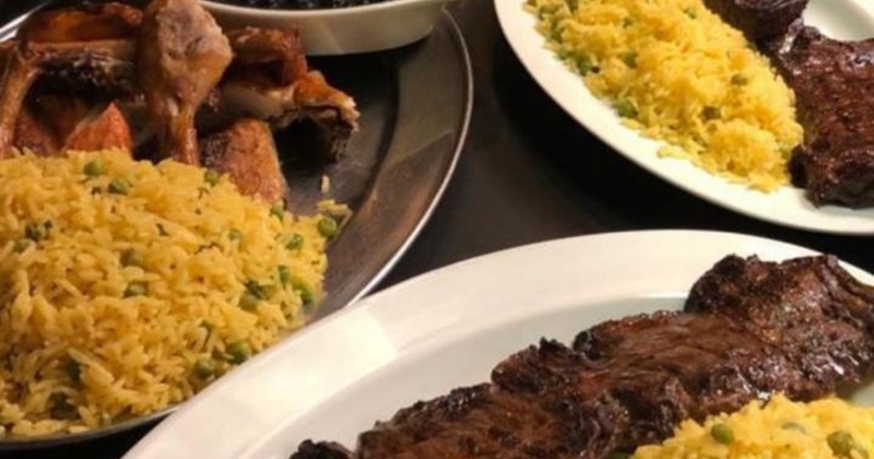 Grilled meat on plates with yellow rice