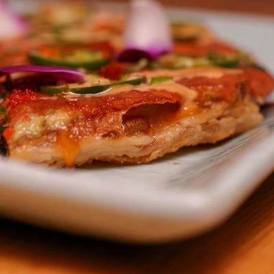 Spicy tuna pizza slice, extreme close up.