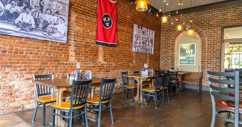 Interior, chairs and tables, flag and painting on brick walls