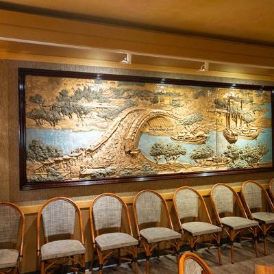 Restaurant interior with a colorful wall painting depicting a scenic view.