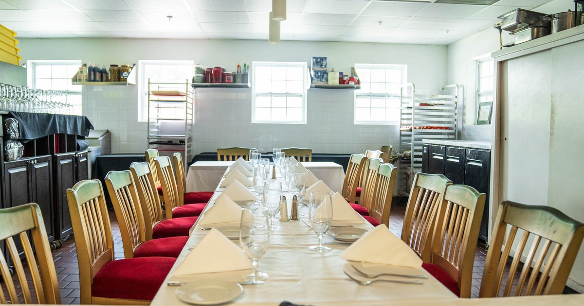 Dining table with plates, napkins, utensils, and glasses