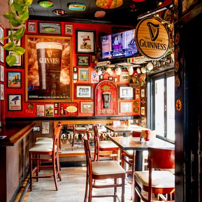 Interior with red walls adorned with vintage beer posters, ceiling decorations, and a TV.