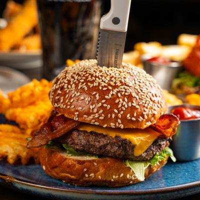 Bacon cheeseburger with lettuce on a sesame seed bun.