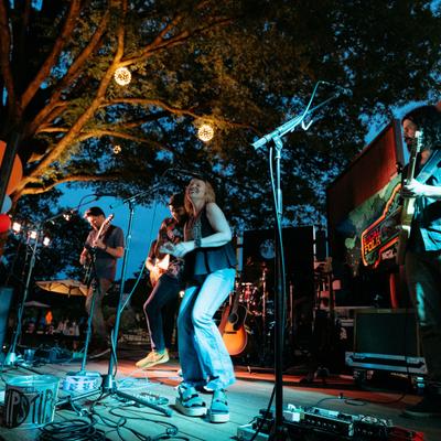 Live band performing on an outdoor stage at night.