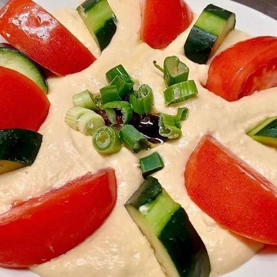 Creamy dip garnished with green onions, cucumber and tomato slices.