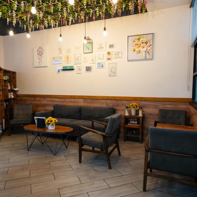 Interior with sofa, several armchairs, decorations and small framed pictures on the wall.