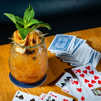 Hot Toddy orange cocktail, playing cards top view