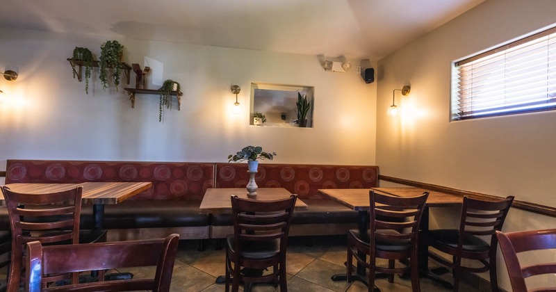 Interior seating area with chairs, tables and wall mounted bench
