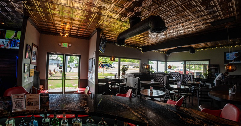 Interior, wide shot of the restaurant, entrance, seating booths and regular tables for four